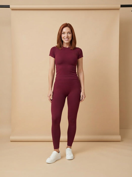 Model wearing the Ribbed Seamless Gym Set in burgundy, studio